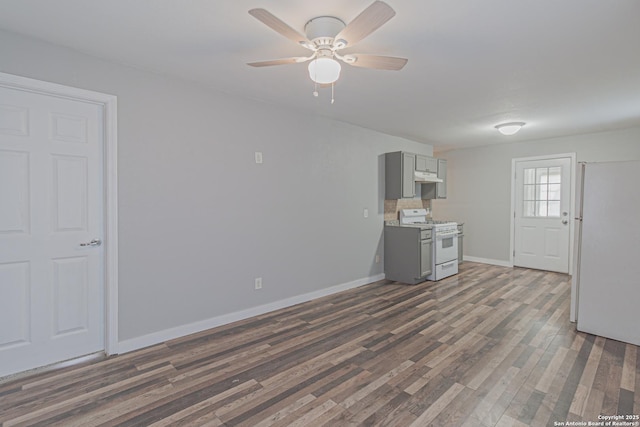 unfurnished living room featuring baseboards, dark wood-style floors, and a ceiling fan