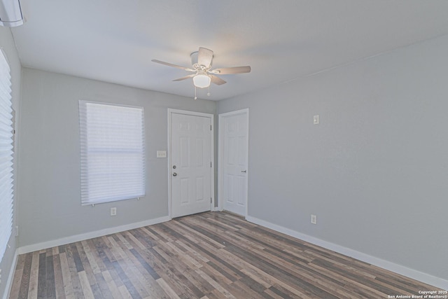 unfurnished room featuring a ceiling fan, baseboards, and wood finished floors