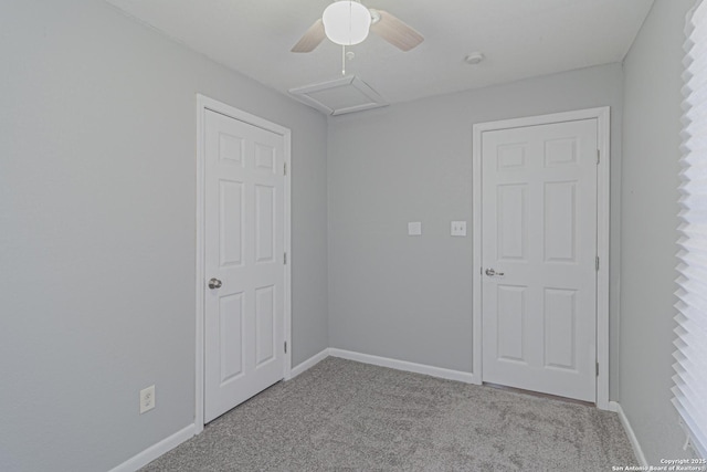 spare room featuring baseboards, ceiling fan, attic access, and carpet