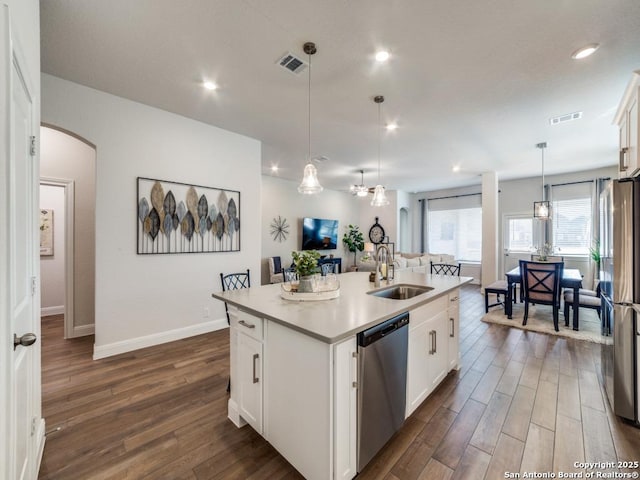 kitchen with visible vents, a sink, open floor plan, arched walkways, and appliances with stainless steel finishes