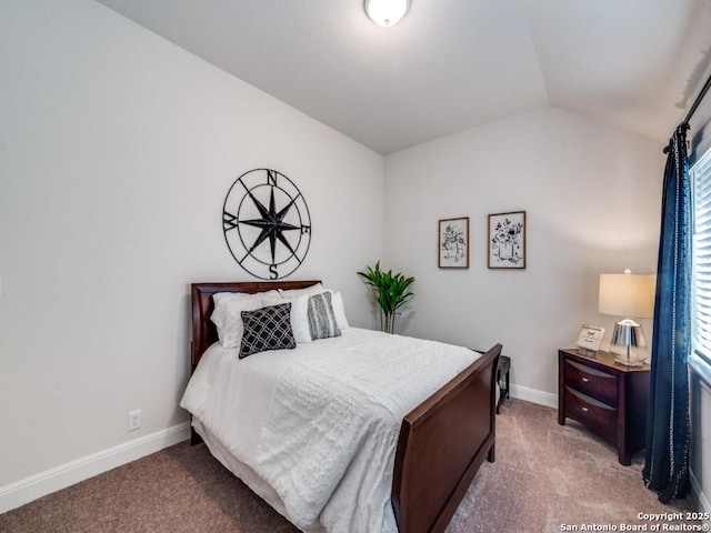 carpeted bedroom with lofted ceiling and baseboards