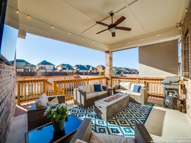 view of patio / terrace featuring a deck, an outdoor living space with a fire pit, a ceiling fan, and a residential view