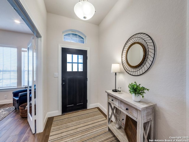 foyer with baseboards and wood finished floors