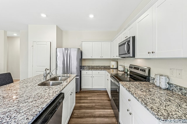 kitchen with white cabinets, stainless steel appliances, dark wood-type flooring, and a sink