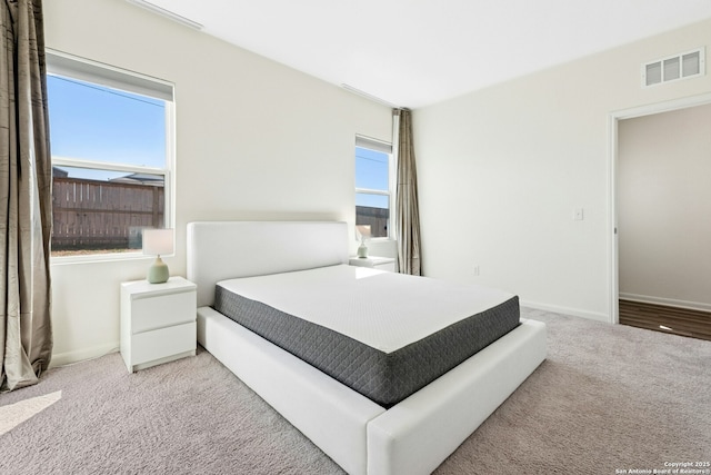 carpeted bedroom with baseboards and visible vents