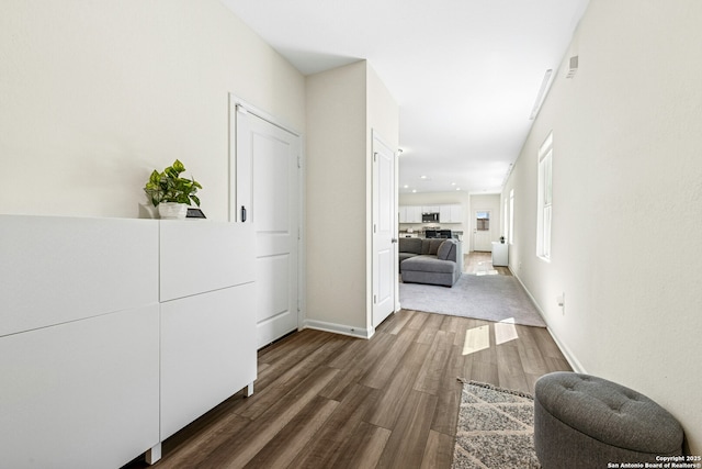 hall with baseboards and wood finished floors