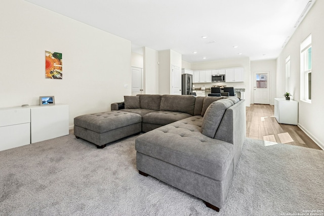 living area with recessed lighting, baseboards, and light wood-style floors