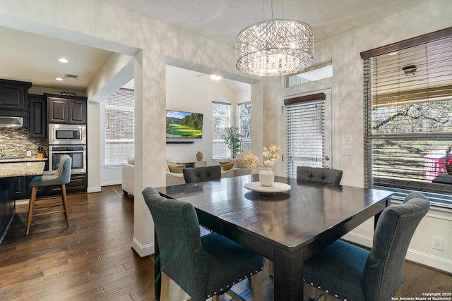 dining space featuring an inviting chandelier, dark wood-type flooring, recessed lighting, and baseboards