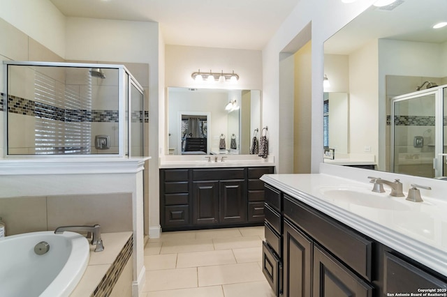 full bathroom featuring tile patterned flooring, a stall shower, a bath, and a sink