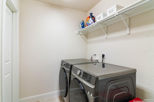 washroom with laundry area, baseboards, and separate washer and dryer