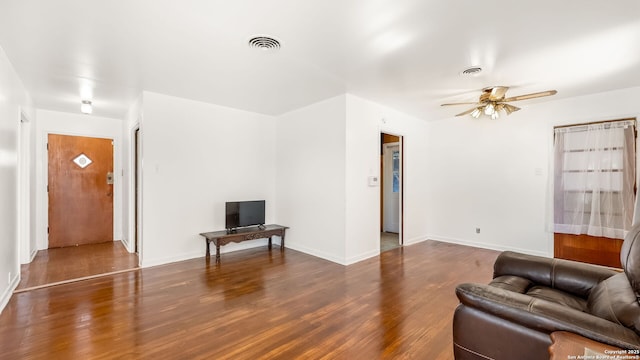 living room with baseboards, wood finished floors, visible vents, and ceiling fan