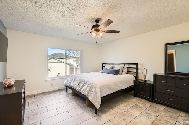 bedroom with light tile patterned flooring, ceiling fan, a textured ceiling, and baseboards