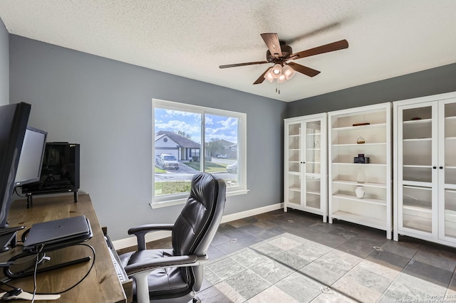 office featuring baseboards, a textured ceiling, and a ceiling fan