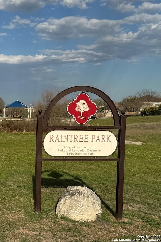 community / neighborhood sign featuring a lawn