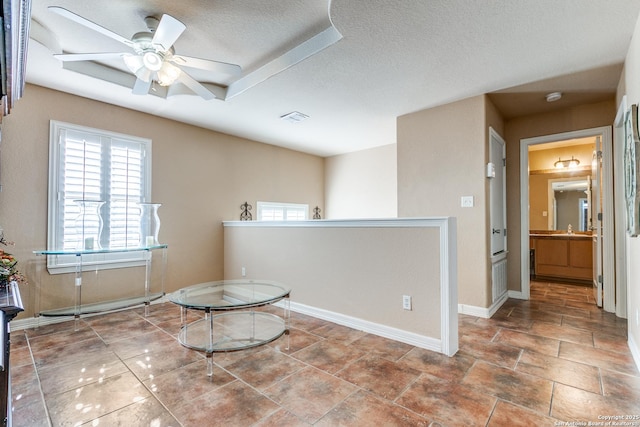 unfurnished room featuring visible vents, plenty of natural light, a textured ceiling, and baseboards