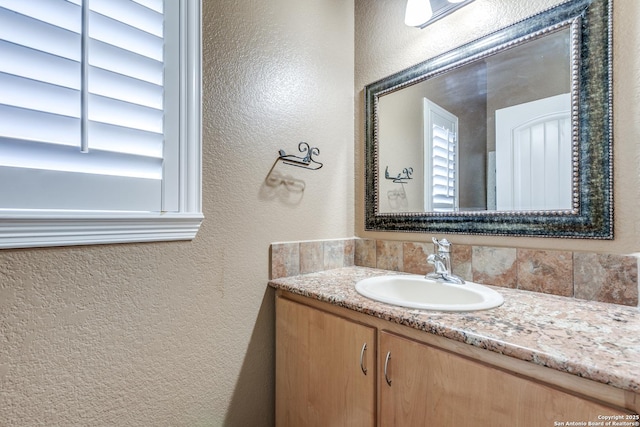 bathroom featuring vanity and a textured wall