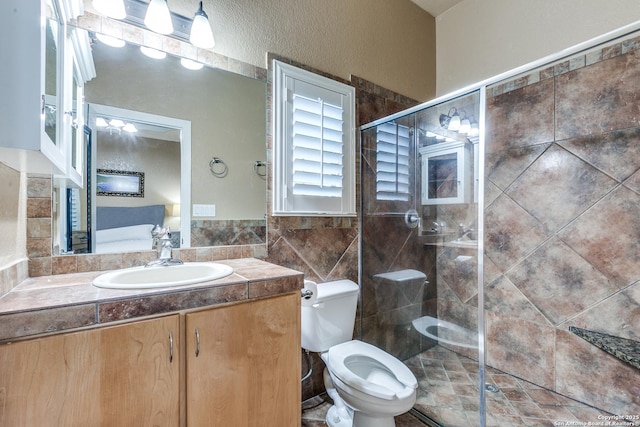 full bathroom featuring vanity, tile walls, toilet, and a stall shower