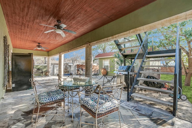 view of patio / terrace with outdoor dining area, a grill, a ceiling fan, and stairway