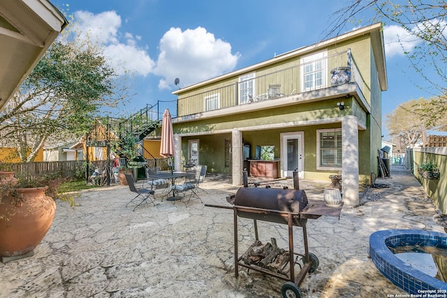 back of house featuring a patio, outdoor dining area, a fenced backyard, and stucco siding