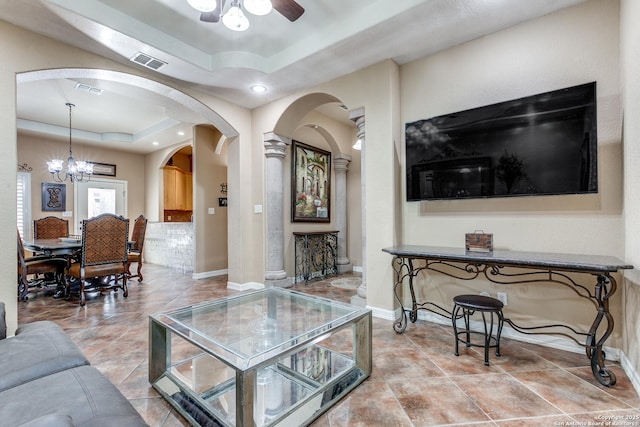 living room with visible vents, baseboards, and a tray ceiling