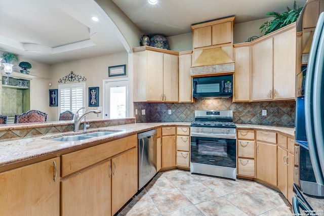 kitchen featuring a sink, decorative backsplash, appliances with stainless steel finishes, and light brown cabinetry