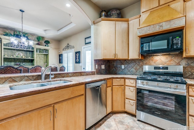 kitchen with light tile patterned floors, a sink, decorative backsplash, appliances with stainless steel finishes, and a raised ceiling