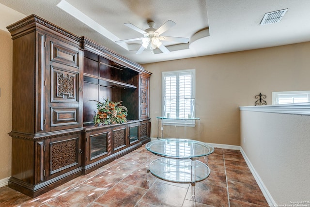 interior space with visible vents, baseboards, tile patterned floors, a textured ceiling, and a ceiling fan