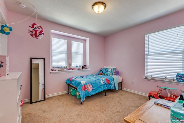 bedroom featuring baseboards and light carpet