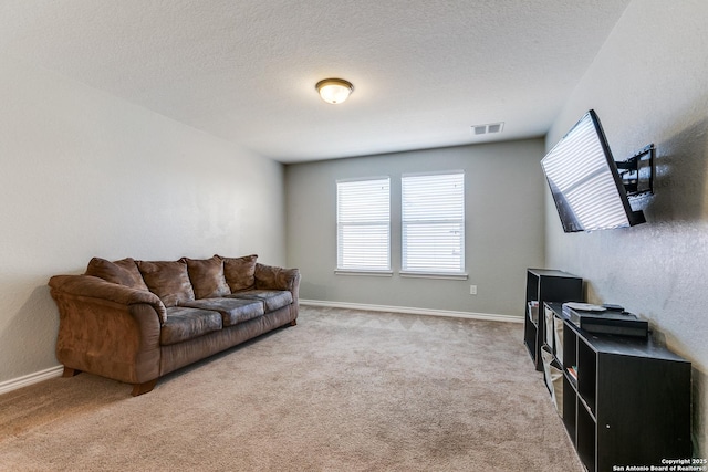 carpeted living room with visible vents, baseboards, and a textured ceiling