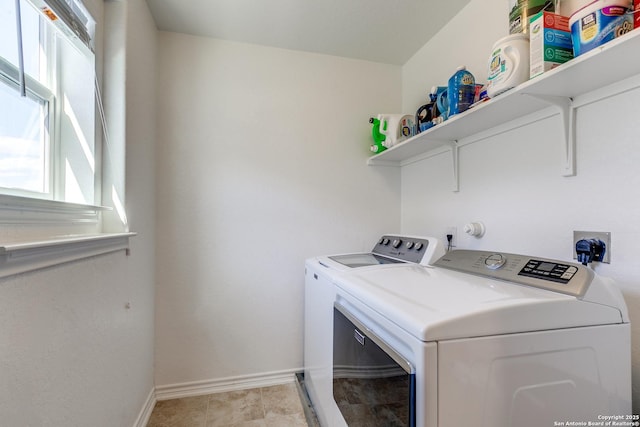 laundry room featuring washing machine and clothes dryer, laundry area, baseboards, and light tile patterned floors