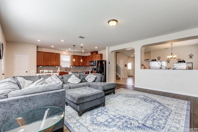 living area with dark wood-style floors, visible vents, stairs, and baseboards