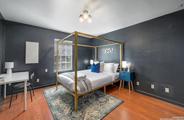 bedroom featuring baseboards and wood finished floors