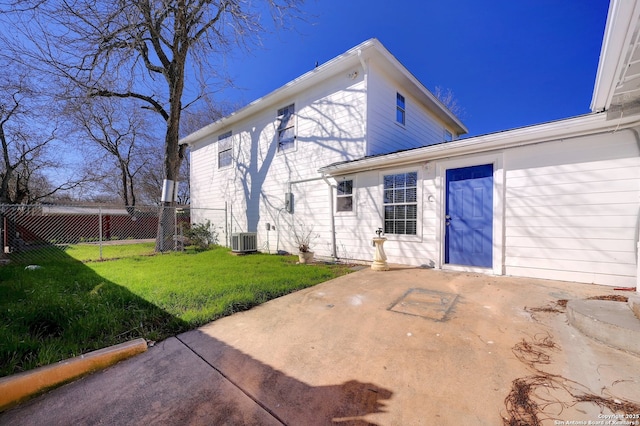 back of property with a patio, a yard, fence, and central AC