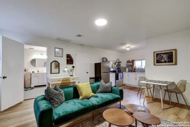 living area with visible vents and light wood-style flooring