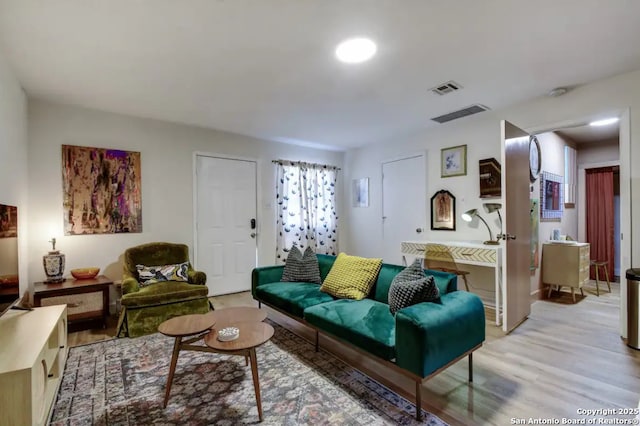 living area with light wood-type flooring and visible vents