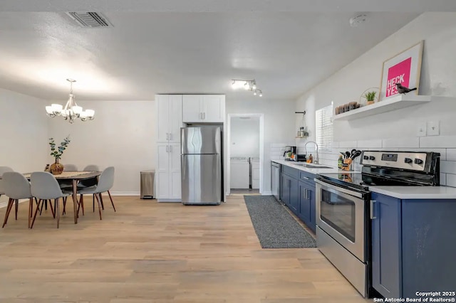 kitchen with washing machine and clothes dryer, visible vents, blue cabinetry, appliances with stainless steel finishes, and open shelves