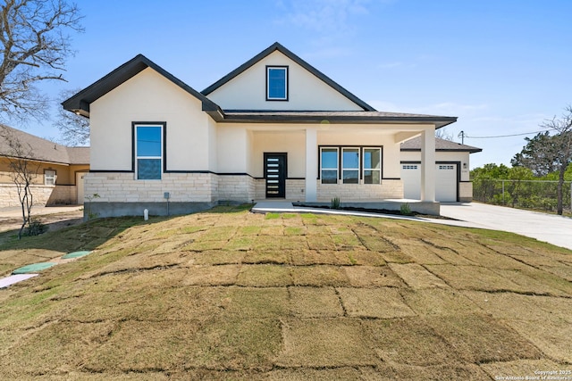 modern farmhouse with an attached garage, stucco siding, concrete driveway, a front lawn, and stone siding