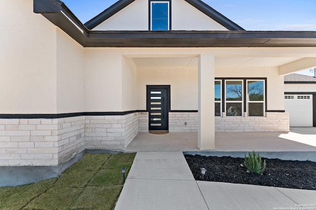 doorway to property featuring covered porch and stucco siding