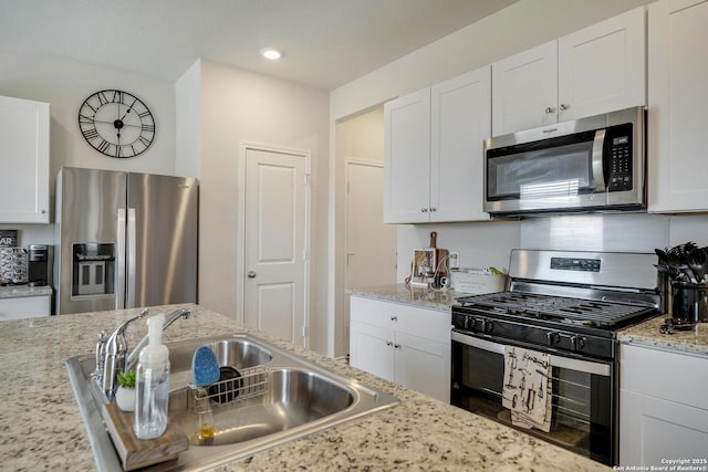 6424 Embankment, San Antonio, TX 78252 - kitchen featuring white cabinets, light stone counters, appliances with stainless steel finishes, and a sink