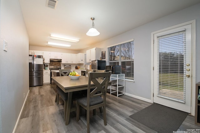 dining room featuring visible vents, baseboards, and dark wood finished floors