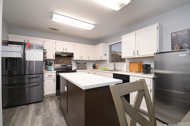 kitchen featuring visible vents, under cabinet range hood, electric stove, stainless steel refrigerator with ice dispenser, and stainless steel refrigerator