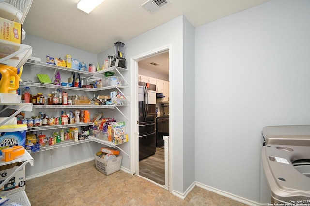 storage area with visible vents and washer / clothes dryer