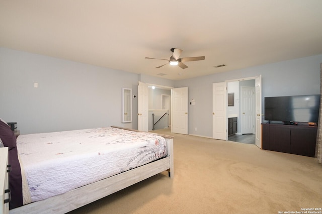 bedroom with ensuite bath, carpet flooring, a ceiling fan, and visible vents