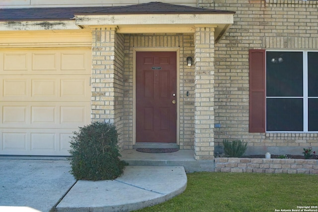 property entrance with brick siding and a garage