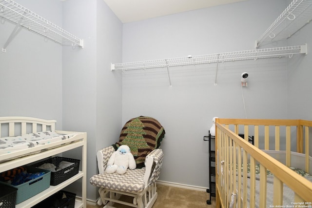 bedroom with baseboards, carpet floors, and a nursery area