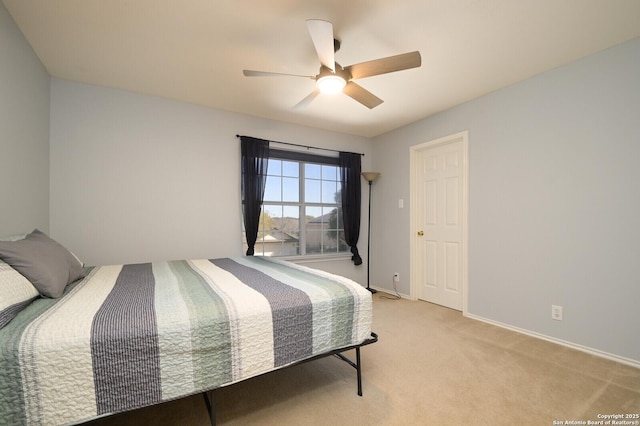 bedroom featuring a ceiling fan, light colored carpet, and baseboards