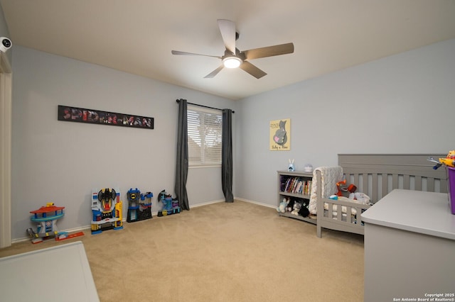 bedroom with baseboards, ceiling fan, a crib, and carpet