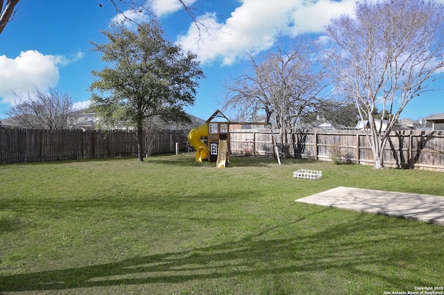 view of yard featuring a playground and a fenced backyard