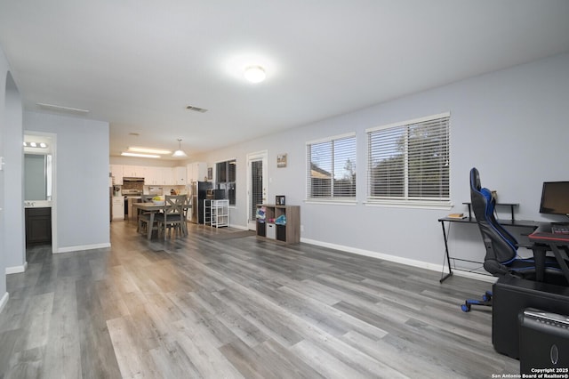 office featuring visible vents, baseboards, and wood finished floors