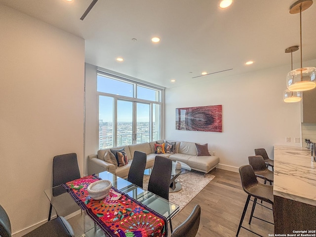 dining area with recessed lighting, expansive windows, baseboards, and wood finished floors